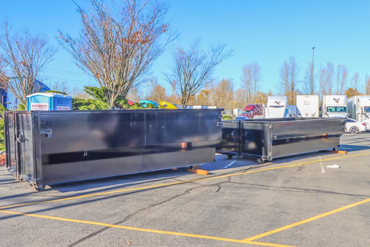 Professional dumpster rental service with roll-off container on residential driveway in College Park